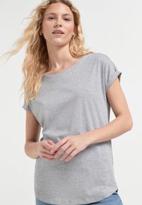 Siva kratka majica za žene s kratkim rukavima, izrađena od mekanog materijala, s opuštenim krojem, okruglim izrezom i preklopljenim rukavima. Jednostavan i svestran dizajn.