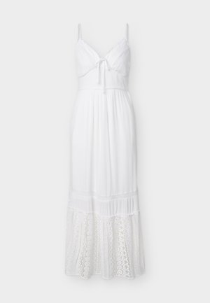 Robe maxi blanche sans manches avec bretelles spaghetti, bustier noué devant, taille cintrée et détails en dentelle sur la partie inférieure de la jupe.