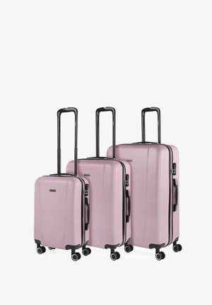 Tres maletas rígidas de color rosa con asas negras y cuatro ruedas, dispuestas por tamaño de pequeña a grande, con asas telescópicas extendidas.