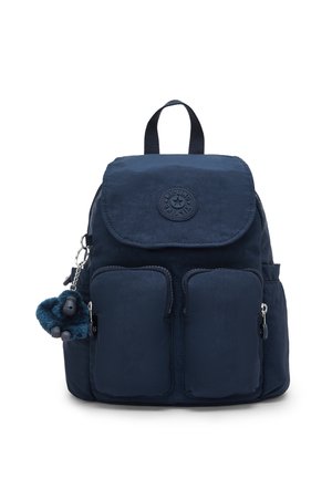 Zaino blu navy con due tasche frontali con cerniera, una patta superiore, una toppa rotonda con logo e un portachiavi con scimmia di peluche attaccato al lato.
