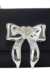 Zwarte stoffen handtas met een zilveren strikaccent en een hartvormige knop bezet met heldere rhinestones. Gladde textuur, compact ontwerp.