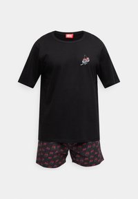 Zwart T-shirt met korte mouwen met een kersengrafiek en een rood Diesel-label. Gecombineerd met korte broek met patroon van rode kersen op een donkere achtergrond.