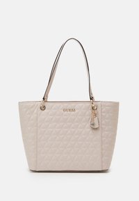 Roze doorgestikte tote tas met dubbele zwarte leren handgrepen, gouden logo en hardware, en een decoratieve hanger bevestigd aan één kant.