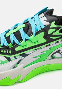 Tenis multicolor cu material alb, verde și negru; accente texturate; șireturi albastre; design grafic dinamic și talpă confortabilă.