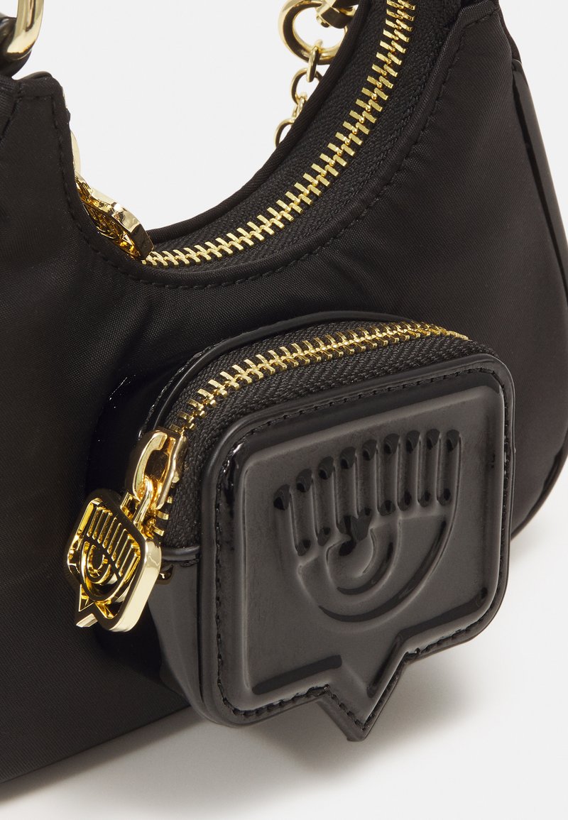 Schwarze Nylon Schultertasche mit goldenen Reißverschlüssen, ausgestattet mit einem kleinen abnehmbaren schwarzen Lackgeldbeutel mit einem erhabenen Augendesign.