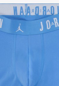 Sømløse lyseblå underbukser med en hvid elastisk talje, der har "JORDAN" og et lille Jumpman-logo. Blødt, strækbart bomuldsstof.