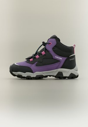 Chaussure de randonnée montante noire et violette avec œillets roses, lacets élastiques, semelle épaisse crantée et les noms des marques Geox et Amphibiox visibles.