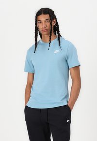 Ljusblå bomullst-shirt med korta ärmar och rund halsringning. Har en liten vit Nike-logga på vänster bröst. Matcha med mörka byxor.