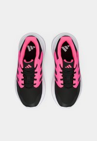 Zwarte sportschoenen met felroze accenten. Het bovenwerk is gemaakt van mesh materialen voor ademend vermogen, met een comfortabele witte zool en zwarte veters.