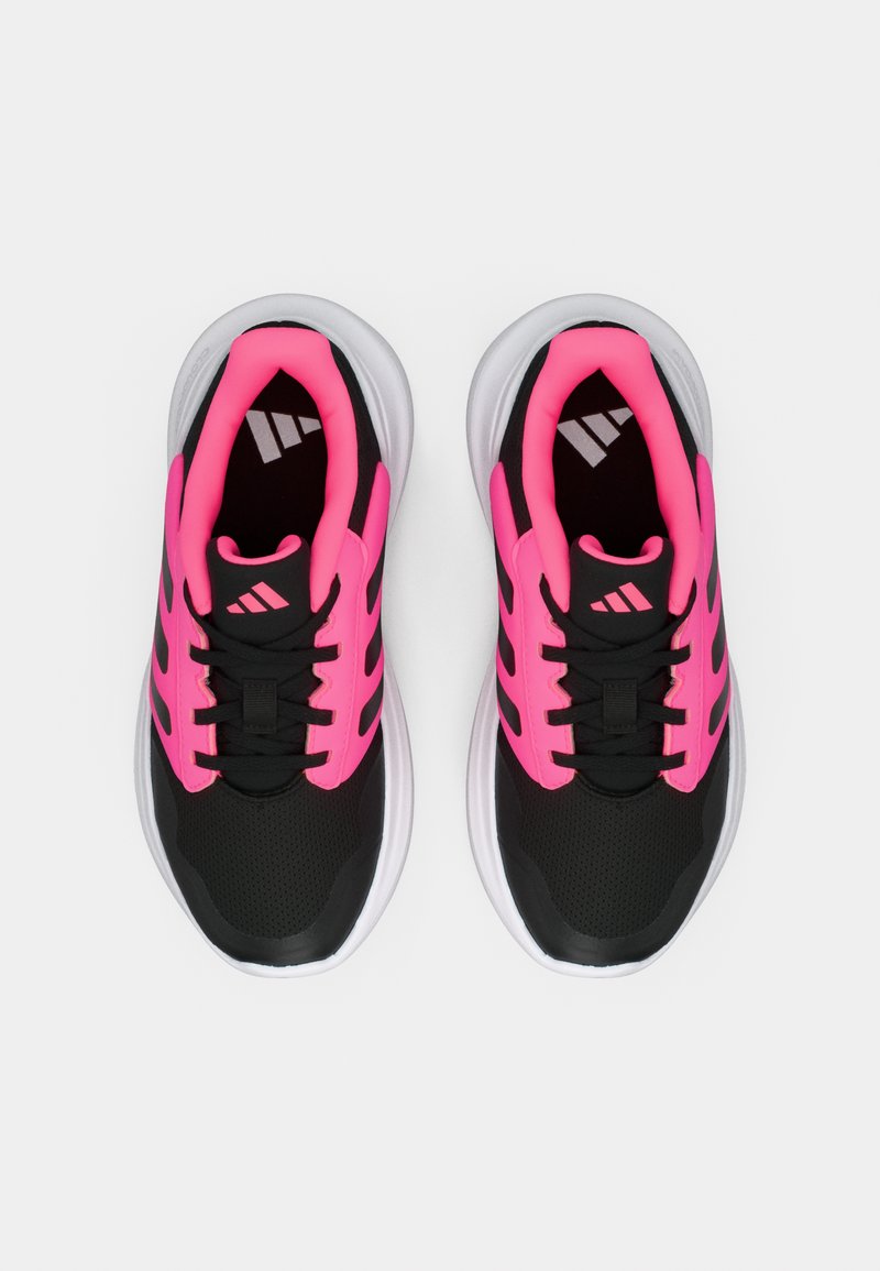 Zapatos deportivos negros con detalles en rosa brillante. La parte superior presenta materiales de malla para transpirable, con una suela blanca acolchada y cordones negros.