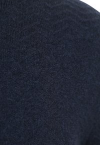 Diepblauwe gebreide stof met een subtiel visgraatpatroon in close-up detail.