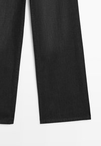 Schwarze Denim-Hosen mit weitem Bein und geradem Schnitt; mit sichtbaren Nähten und einer weichen Textur; am Saum unten abgeschlossen.