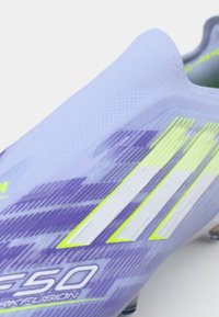 Light blue soccer cleat with purple accents, featuring white and neon yellow stripes, textured material, and a streamlined design.