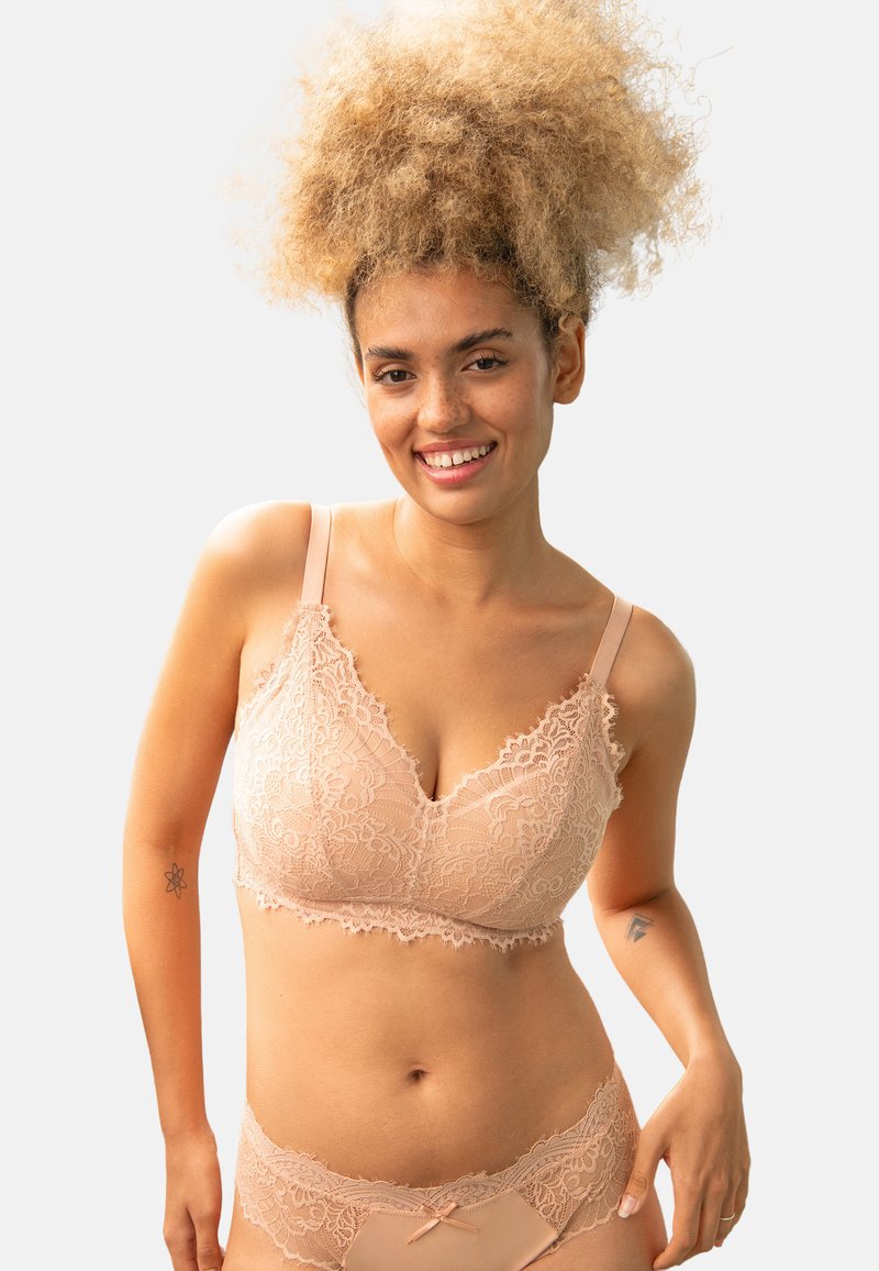 Spitzen-Bralette in hellem Nude-Ton, mit floralen Mustern, gewellten Kanten und verstellbaren Trägern. Ergänzt das passende Spitzenunterwäsche.