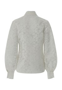 White, long-sleeve blouse featuring a textured floral pattern, a collared neck, and elasticized cuffs, with a smooth, sheer fabric finish.