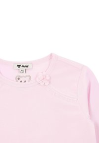 Roze langermige shirt van katoen. Heeft een kleine bloemenaccent bij de halslijn en een berenlogo op het label. Zachte textuur, eenvoudig ontwerp.