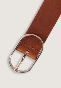 Ceinture en cuir marron avec une texture lisse, dotée d'une boucle circulaire en argent et de détails de couture subtils sur la sangle.