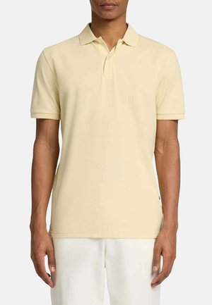 Polo a maniche corte di colore giallo chiaro, realizzato in tessuto morbido. Presenta un colletto classico e una linea dritta con dettagli minimi.