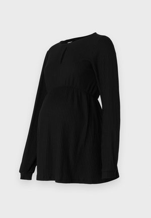 Musthave mustrasedega mustrasedega vöökoht, ümar kaelus ja väike aukdetail ees.