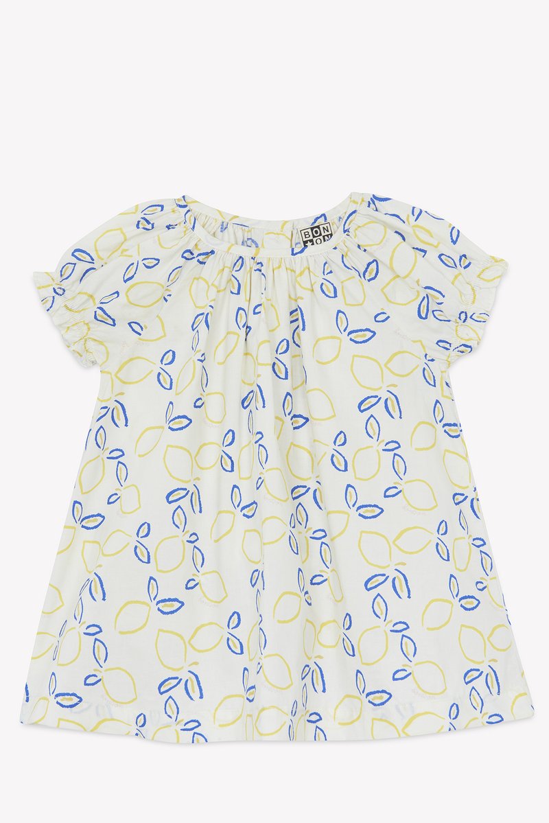 White short-sleeve dress with yellow and blue leaf patterns, elasticated neckline, and subtle gathered detailing for added texture.