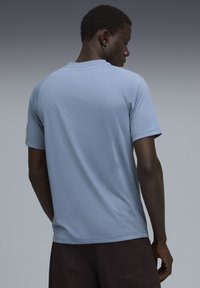 Lyseblå kortærmet t-shirt med rund hals og en glat tekstur, som viser et enkelt design uden synlige mønstre eller accenter.