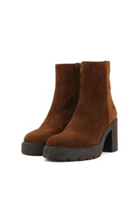 Stivali alla caviglia in suede marrone con tacco spesso, zip laterale e suola platform. Texture liscia con un design elegante.