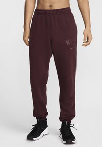Bordeauxfärgade sweatpants med elastiskt midjeband och muddar, med en subtil NIKE-logotyp i mörkgrått. Tillverkade av mjukt, andningsbart tyg.