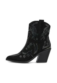 Botín de ante negro con punta afilada, adornado con tachuelas metálicas, patrones de estrellas y un tacón grueso. Costura detallada en el eje.