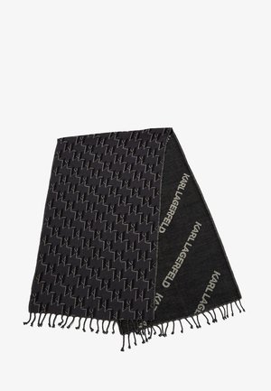 Écharpe noire avec un motif géométrique et des bords à franges. Le matériau semble doux avec une combinaison de sections unies et à motifs.