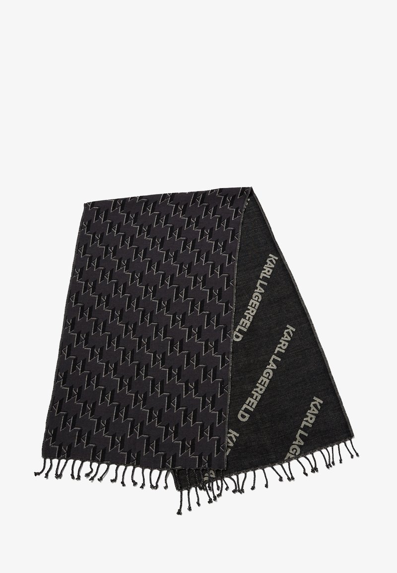 Écharpe noire avec un motif géométrique et des bords à franges. Le matériau semble doux avec une combinaison de sections unies et à motifs.