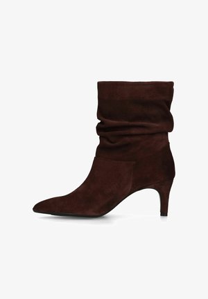 Donkerbruine suède laars tot halverwege de kuit met een losvallende pasvorm, puntige neus en slanke hak van 6,5 cm, zijaanzicht op witte achtergrond.