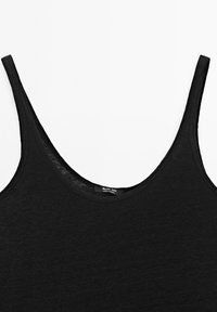 Svart ärmlös linne med rundad halsringning, tillverkat av mjukt tyg med en subtil struktur. Etikett synlig inuti halsringningen.