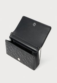 Clutch bag nera in pelle trapuntata con chiusura a scatto argentata, patta aperta e sottile tracolla su uno sfondo bianco.