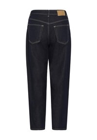 Jean en denim bleu foncé avec poches arrière, coutures blanches et un petit patch en cuir de la marque sur la ceinture.