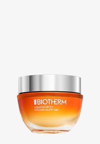 Żel Biotherm Aquasource+ Vitamin Glow w okrągłym szklanym słoiku z gradientową pomarańczową podstawą i srebrną nakrętką. Gładka, przezroczysta tekstura.