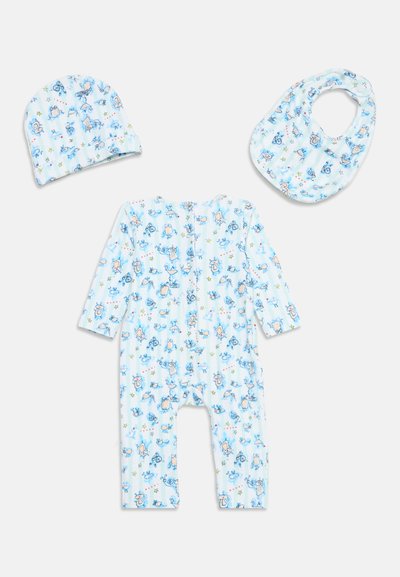 Chapeau bleu bébé à motifs, bavoir et body à manches longues avec imprimés d'animaux dessinés et d'étoiles sur fond blanc.