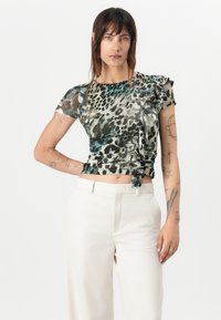 Bluză ajustată, cu mânecă scurtă, cu un imprimeu animalier în nuanțe de verde, gri și negru. Material moale și transparent, cu umeri increțiți și detalii înnodate la talie.