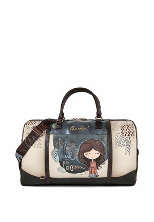 Borsa sportiva color crema e nera con illustrazione di una ragazza dei cartoni animati, manici scuri e tracolla staccabile con motivi decorativi ricamati.