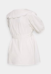 Vestido de algodão branco com gola ondulada, mangas curtas em balão, cintura cingida com cinto e silhueta rodada, exibido pela parte de trás.