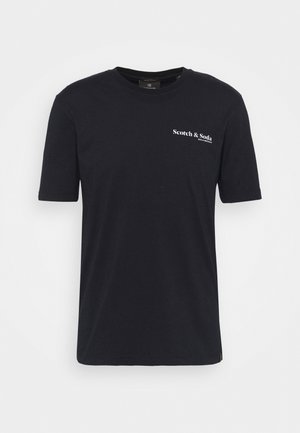 Schwarzes Baumwoll-T-Shirt mit kurzen Ärmeln, Rundhalsausschnitt, mit dem weißen "Scotch & Soda"-Logo, das auf der oberen linken Brustseite gedruckt ist.