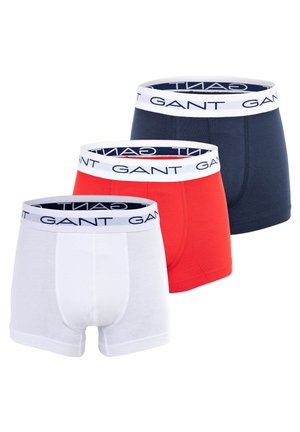 Trio de boxer briefs pour hommes en blanc, rouge et bleu marine avec des ceintures élastiques arborant le nom de la marque « GANT » en impression contrastée.