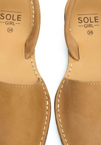 Brown leather sandals with a smooth texture, open toe design, and contrasting white stitching. Features branding "SOLE GIRL" and size 38.