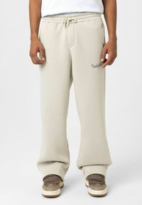 Lichtbeige sweatpants met elastische tailleband, verstelbare koord, twee zijzakken en geborduurd logo op de dij.
