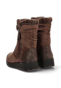 Botas de tobillo de ante marrón con forro de pelaje sintético, cierre de cremallera y tacón texturizado mate marrón. Presenta un diseño recogido a lo largo del tobillo.