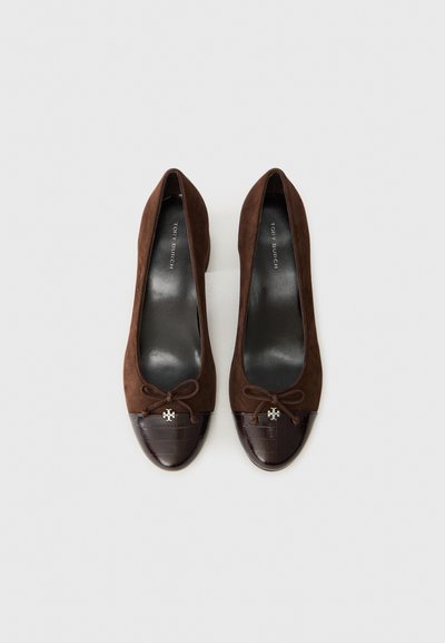 Ballerines en suede marron avec un bout en croûte de cuir texturé marron foncé, ornées d'un petit logo en argent et d'un détail nœud à l'avant.
