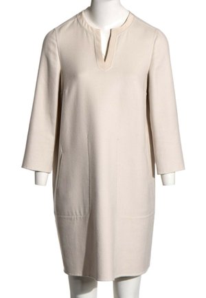Vestido color crema hasta la rodilla con mangas tres cuartos y escote redondo con una pequeña abertura en forma de V.