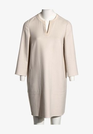 Vestido color crema hasta la rodilla con mangas tres cuartos y escote redondo con una pequeña abertura en forma de V.