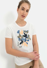 Witte t-shirt met een bloemenprint in oranje, marineblauw, groen en zwart. Korte mouwen en een ronde halslijn. Casual pasvorm.