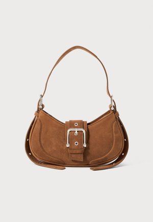 Brown suede handbag with a curved shape, prominent silver buckle detail, and adjustable strap, featuring stitched accents and snap closures.