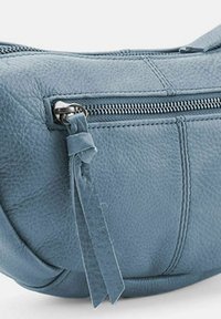 Borsa a tracolla in pelle azzurro chiaro con superficie texture, dotata di chiusura a zip e tirazip decorativo con dettaglio a frangia.